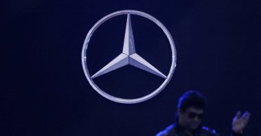 A man walks past the logo of Mercedes-Benz at a gathering in New Delhi, India, Feb. 1, 2024. (Reuters Photo)