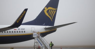 A ground handling worker walks past a Ryanair Boeing 737-8AS aircraft at Warsaw-Modlin Airport, Modlin, Poland, Dec. 1, 2025.  (Reuters Photo)