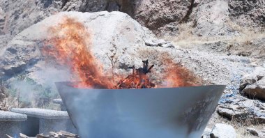 A pit filled with weapons is set on fire by the PKK during a ceremony, Sulaimaniyah, Iraq, July 11, 2025. (AFP Photo)