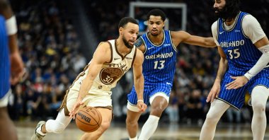 Golden State Warriors guard Stephen Curry (L) drives to the basket against Orlando Magic guard Jett Howard (C) and center Goga Bitadze (35) in the fourth quarter at Chase Center, San Francisco, U.S., Dec. 22, 2025: (Reuters Photo)