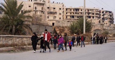 People walk together along a street after YPG/PKK shelling in Aleppo, Dec. 23, 2025. (Reuters Photo)