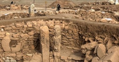 A pillar and a human statue stand at the archaeological site of Karahantepe in the southeastern city of Şanlıurfa, Türkiye, Nov. 26, 2025. (AFP Photo)