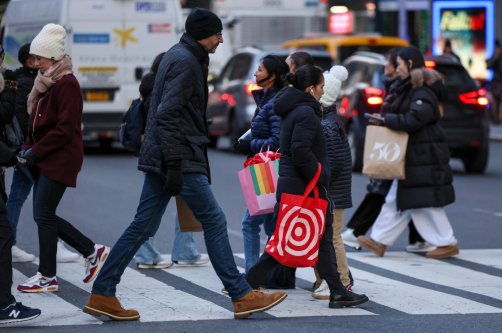 People hold shopping bags as they make their way through Herald Square in New York City, U.S., Dec. 11, 2025. (AFP Photo)