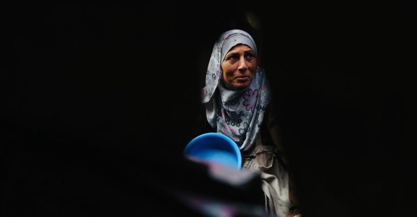 A displaced Palestinian woman waits with her container to receive donated food portions at a charity kitchen in Khan Yunis in the southern Gaza Strip, Palestine, Dec. 17, 2025. (AFP Photo)