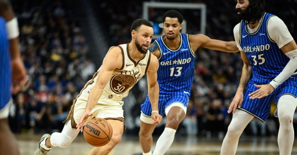Golden State Warriors guard Stephen Curry (L) drives to the basket against Orlando Magic guard Jett Howard (C) and center Goga Bitadze (35) in the fourth quarter at Chase Center, San Francisco, U.S., Dec. 22, 2025: (Reuters Photo)
