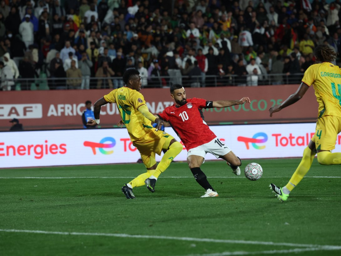 Zimbabwe's Teenage Hadebe (L) challenges as Egypt's Mohamed Salah goes on to score the second goal during the Africa Cup of Nations (CAN) group B football match at Adrar Stadium, Agadir, Morocco, Dec. 22, 2025. (AFP Photo)