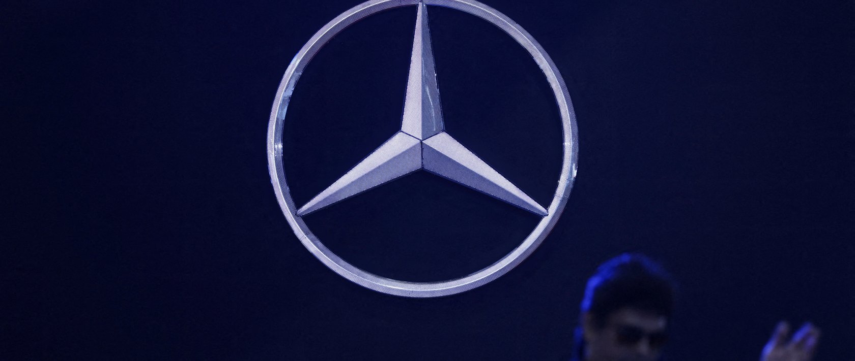 A man walks past the logo of Mercedes-Benz at a gathering in New Delhi, India, Feb. 1, 2024. (Reuters Photo)