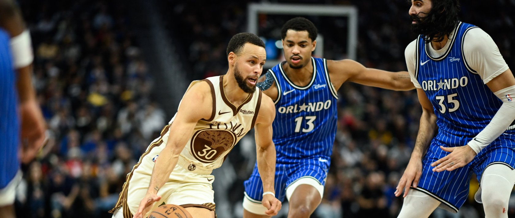 Golden State Warriors guard Stephen Curry (L) drives to the basket against Orlando Magic guard Jett Howard (C) and center Goga Bitadze (35) in the fourth quarter at Chase Center, San Francisco, U.S., Dec. 22, 2025: (Reuters Photo)