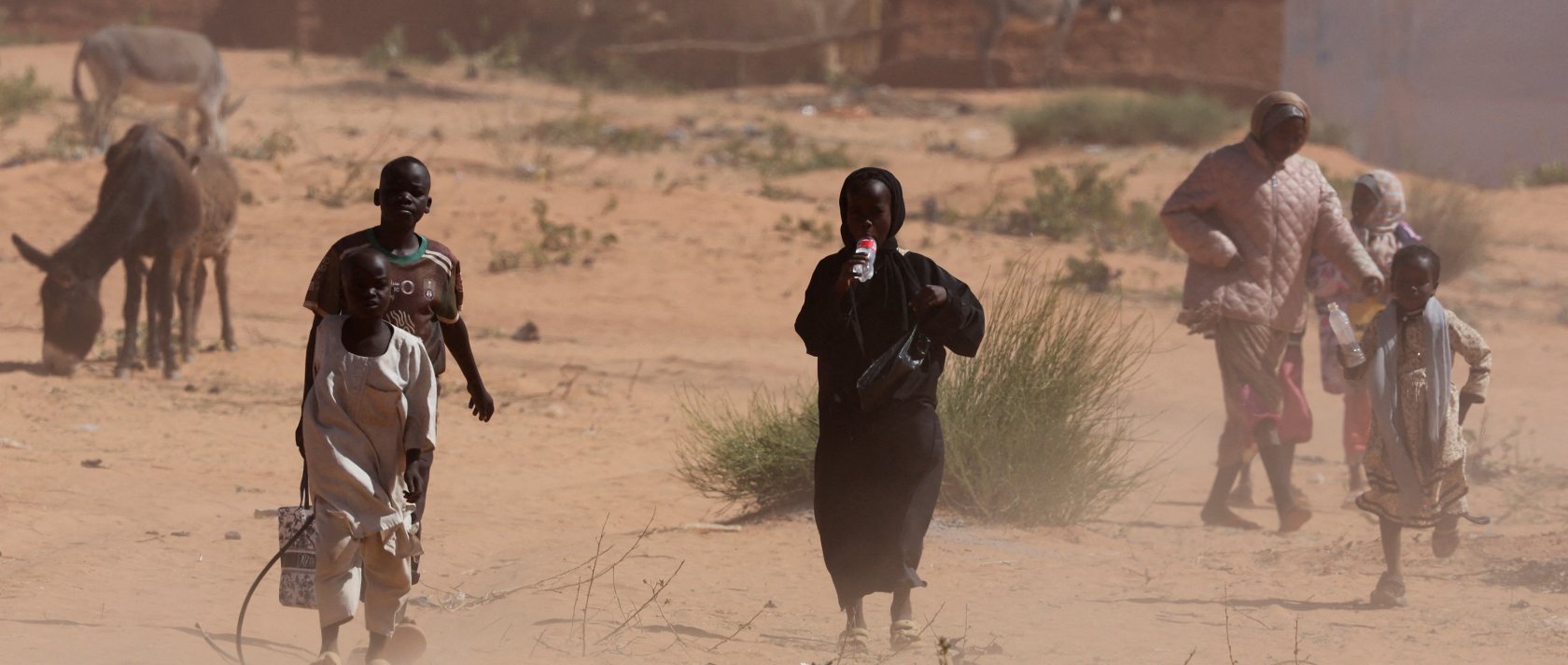 Sudanese refugees from Darfur walk amidst a sandstorm at the Touloum refugee camp, in Wadi Fira province, Chad, Nov. 30, 2025. (Reuters Photo)