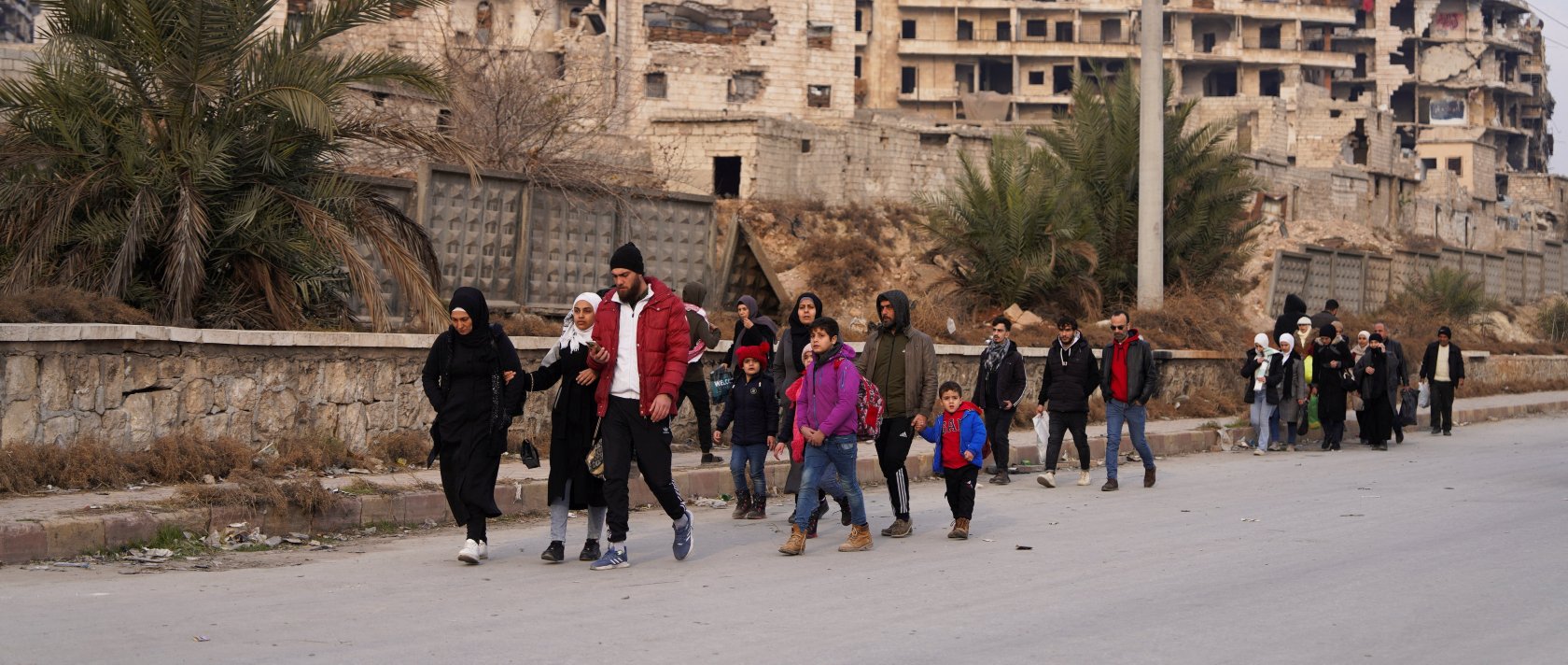 People walk together along a street after YPG/PKK shelling in Aleppo, Dec. 23, 2025. (Reuters Photo)