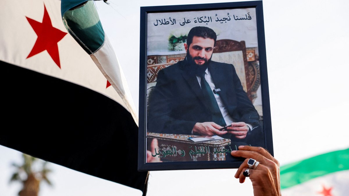 A person holds up an image of Syrian President Ahmed al-Sharaa during a protest in support of Syrian territorial unity and against division, Damascus, Syria, Nov. 28, 2025. (Reuters Photo)