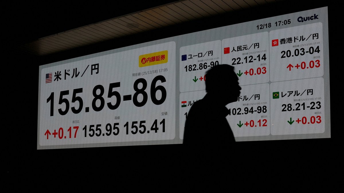 A man is silhouetted against a board displaying the exchange rate between the Japanese yen and U.S. dollar outside a brokerage, Tokyo, Japan, Dec. 18, 2025. (Reuters File Photo)