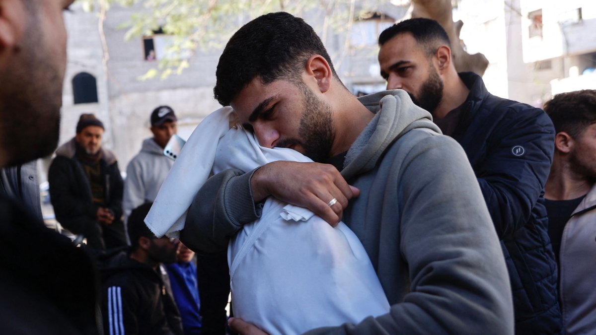 A Palestinian man carries the body of his 5-month-old brother, Ahmed Al-Nader, who was reportedly killed the previous day along with other family members in an Israeli shelling on a school-turned-shelter, ahead of his funeral in the Tuffah neighbourhood of Gaza City, Dec. 20, 2025. (AFP Photo)
