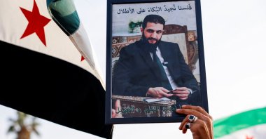 A person holds up an image of Syrian President Ahmed al-Sharaa during a protest in support of Syrian territorial unity and against division, Damascus, Syria, Nov. 28, 2025. (Reuters Photo)