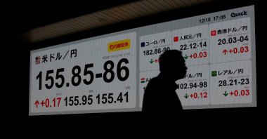 A man is silhouetted against a board displaying the exchange rate between the Japanese yen and U.S. dollar outside a brokerage, Tokyo, Japan, Dec. 18, 2025. (Reuters File Photo)