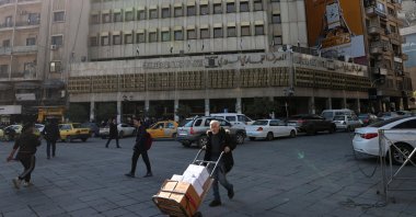 A man walks past the Commercial Bank of Syria, Damascus, Syria, Dec. 18, 2025. (Reuters Photo)