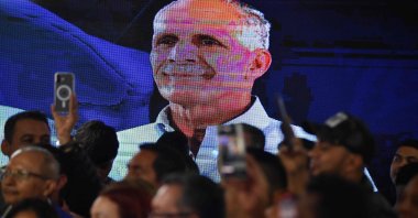 An LCD screen displays a portrait of Honduras presidential candidate Nasry Asfura of the National Party, as supporters celebrate after the National Electoral Council (CNE) declares him the winner of the Honduras Presidential Election in Tegucigalpa, Honduras, Dec. 24, 2025. (AFP Photo)