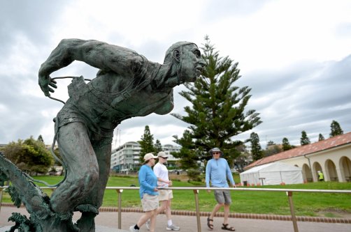 People walk past the Surf Life Saver statue at Bondi Beach as life gradually returns to normal following seven days of mourning, in Sydney, Australia, Dec. 22, 2025. (AFP Photo)