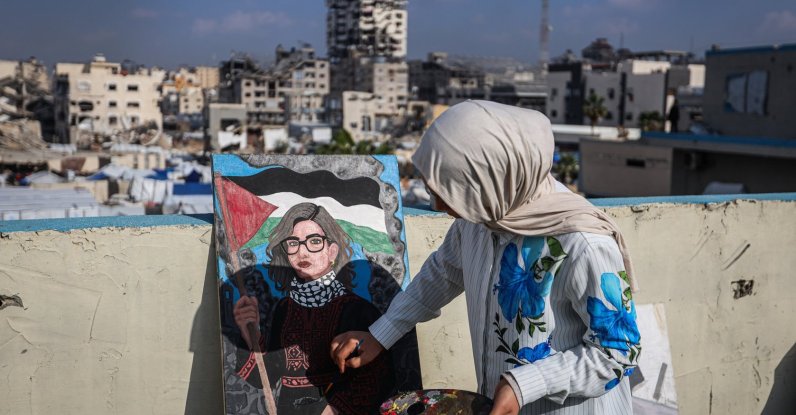 Fifteen-year-old painter Sara Abu Saade paints with the destroyed buildings of Gaza City in the background, Gaza Strip, Palestine, Dec. 23, 2025. (AA Photo)