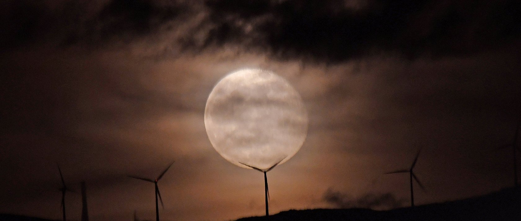 The full moon rises over a wind turbine in Nafplion, Peloponnese region, Greece, Dec. 6, 2025. (EPA Photo)