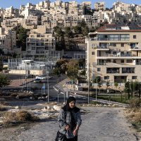 A Palestinian woman walks past the Israeli settlement of Har Homa, southeast of Jerusalem, Nov. 21, 2025. (AFP Photo)