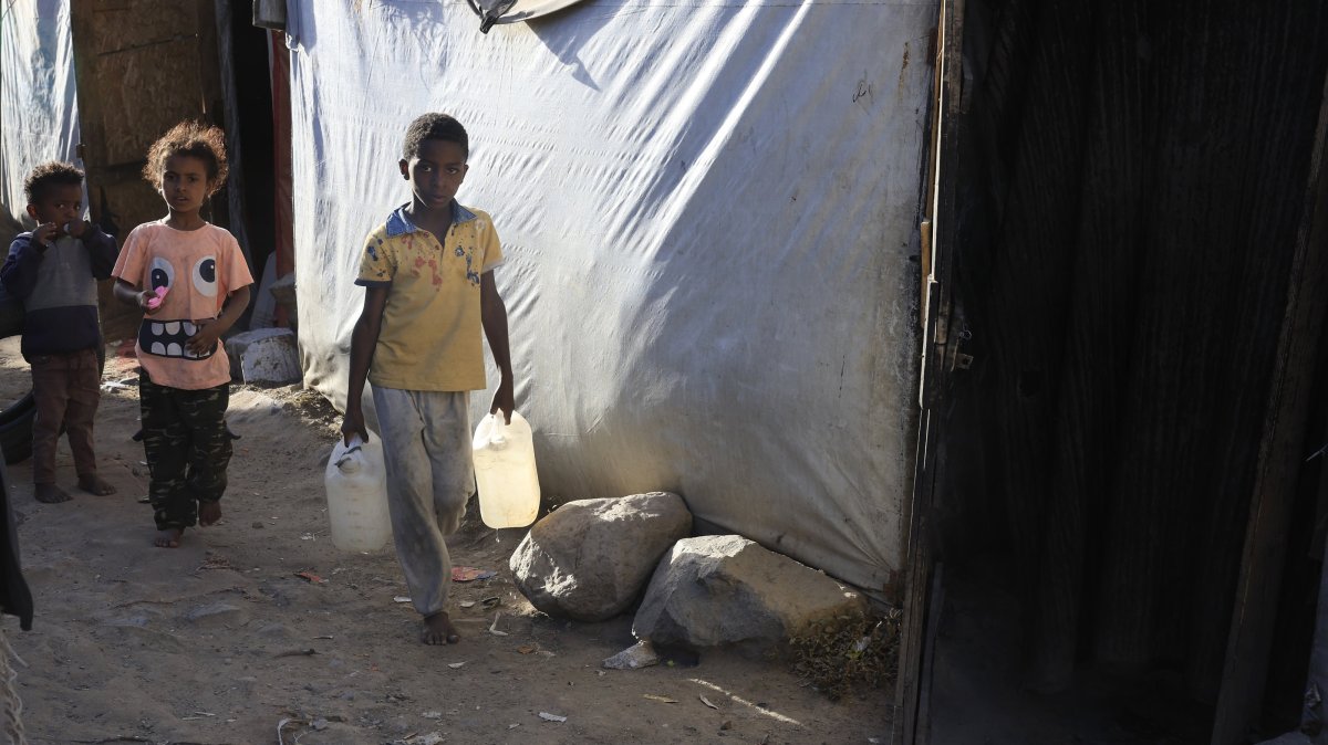 A displaced Yemeni boy holds bottles of water at a makeshift camp for Internally Displaced Persons (IDPs) in Sana'a, Yemen, Dec. 24, 2025. (EPA Photo)