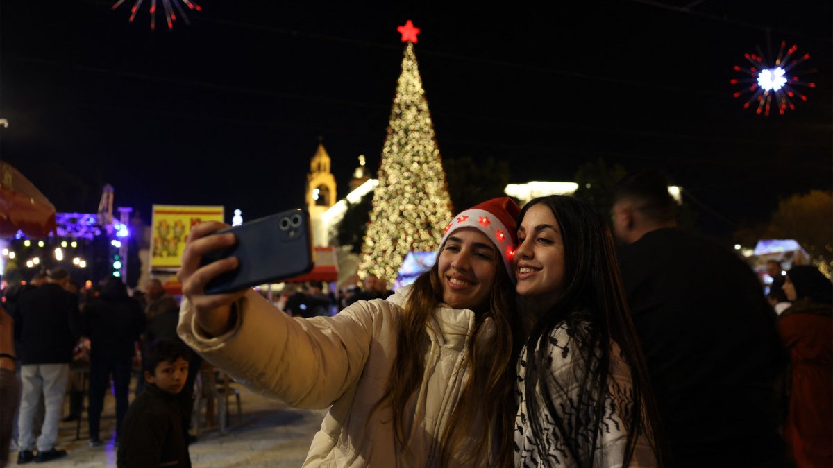 Palestinians take a photo in the Nativity Square with pilgrims and people before midnight mass at the Nativity Church in Bethlehem, in the Israeli-occupied West Bank, Dec. 24, 2025. (AFP Photo)