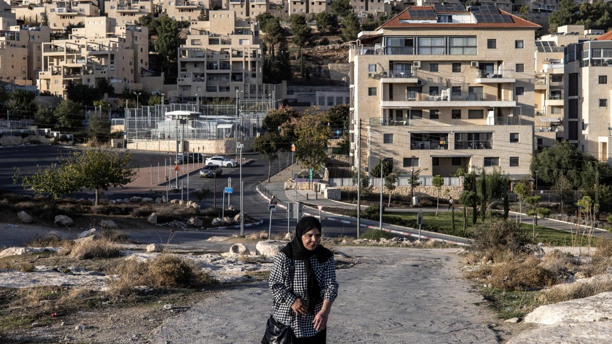A Palestinian woman walks past the Israeli settlement of Har Homa, southeast of Jerusalem, Nov. 21, 2025. (AFP Photo)