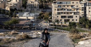 A Palestinian woman walks past the Israeli settlement of Har Homa, southeast of Jerusalem, Nov. 21, 2025. (AFP Photo)