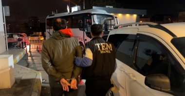 A police officer escorts a captured suspect, Istanbul, Türkiye, Dec. 25, 2025. (DHA Photo)
