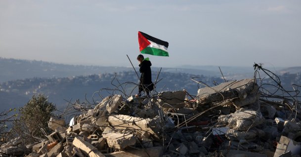A Palestinian boy waves a Palestinian flag over the rubble of the home belonging to the family of Malik Ismail Salem in Bizarya village near Nablus, occupied West Bank, Palestine, Dec. 24, 2025. (EPA Photo)