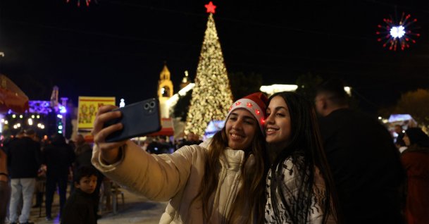 Palestinians take a photo in the Nativity Square with pilgrims and people before midnight mass at the Nativity Church in Bethlehem, in the Israeli-occupied West Bank, Dec. 24, 2025. (AFP Photo)