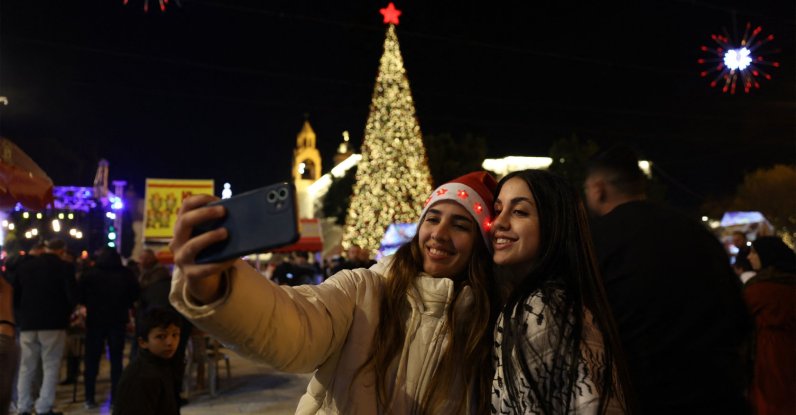 Palestinians take a photo in the Nativity Square with pilgrims and people before midnight mass at the Nativity Church in Bethlehem, in the Israeli-occupied West Bank, Dec. 24, 2025. (AFP Photo)