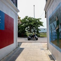 A motorist commutes past paintings on a wall of the Taiwan flag and a soldier in Taiwan's Kinmen, May 18, 2024. (AFP Photo)