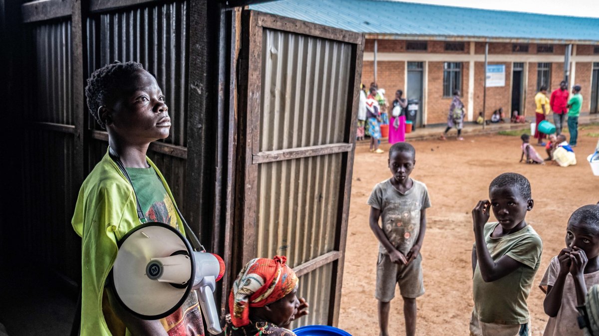 A young refugee from stands with a megaphone to give instructions to other refugees at a food distribution point at Nyarushishi Transit Camp, Rusizi district, DRC, Dec. 11, 2025. (AFP Photo)