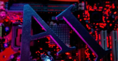 Letters spelling out "AI" and a robot hand are placed on a computer motherboard in this illustration created on June 23, 2023. (Reuters Photo)