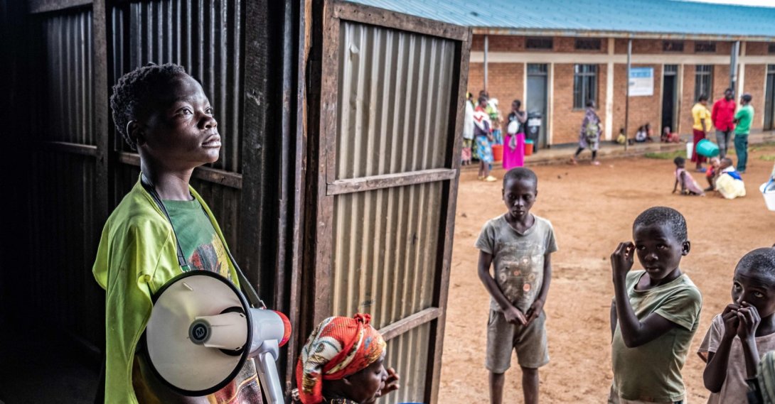 A young refugee from stands with a megaphone to give instructions to other refugees at a food distribution point at Nyarushishi Transit Camp, Rusizi district, DRC, Dec. 11, 2025. (AFP Photo)