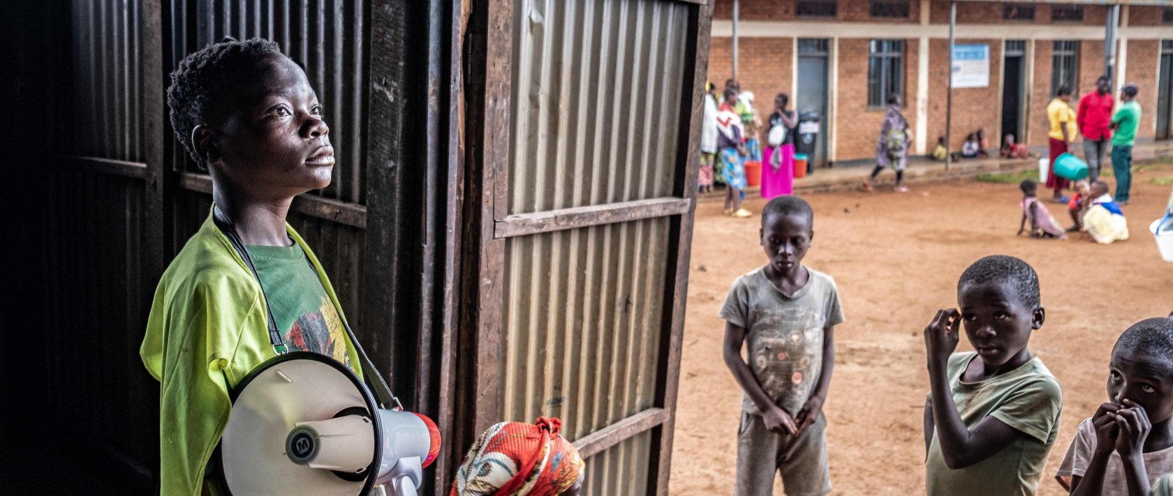 A young refugee from stands with a megaphone to give instructions to other refugees at a food distribution point at Nyarushishi Transit Camp, Rusizi district, DRC, Dec. 11, 2025. (AFP Photo)