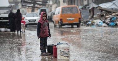 A displaced Palestinian child looks on amid a rainstorm in the western Gaza Strip, Dec. 27, 2025. (AA Photo)