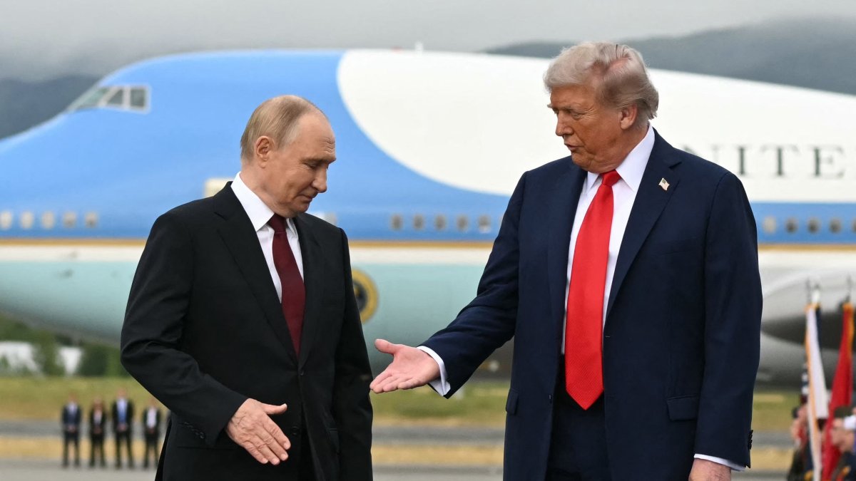 U.S. President Donald Trump (R) reaches out to shake hands with Russian President Vladimir Putin as they pose on a podium on the tarmac after arrival at Joint Base Elmendorf-Richardson in Anchorage, Alaska, Aug. 15, 2025. (AFP Photo)