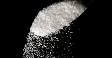 This photo illustration shows granulated sugar falling from a spoon, Philadelphia, U.S., Sept. 12, 2016. (AP Photo)