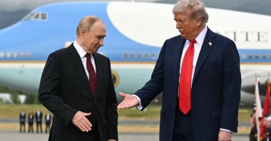 U.S. President Donald Trump (R) reaches out to shake hands with Russian President Vladimir Putin as they pose on a podium on the tarmac after arrival at Joint Base Elmendorf-Richardson in Anchorage, Alaska, Aug. 15, 2025. (AFP Photo)