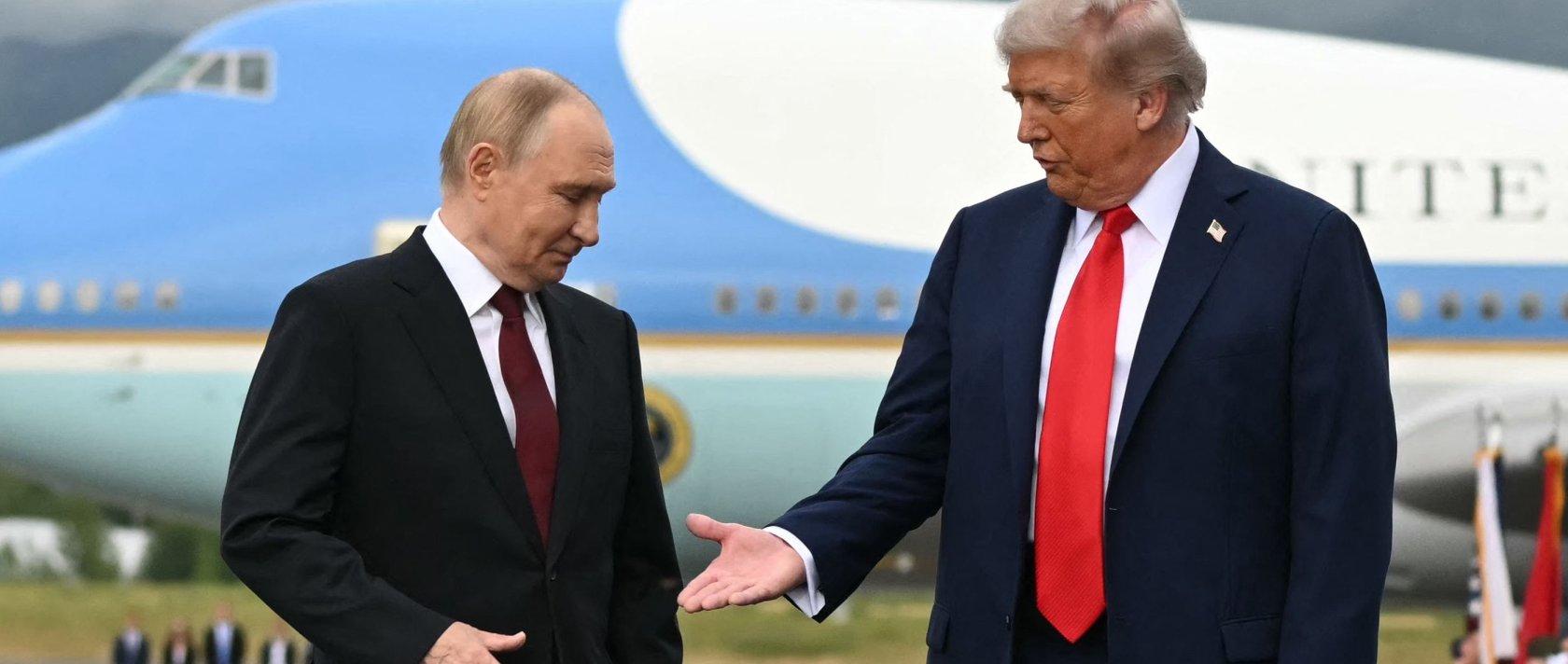 U.S. President Donald Trump (R) reaches out to shake hands with Russian President Vladimir Putin as they pose on a podium on the tarmac after arrival at Joint Base Elmendorf-Richardson in Anchorage, Alaska, Aug. 15, 2025. (AFP Photo)