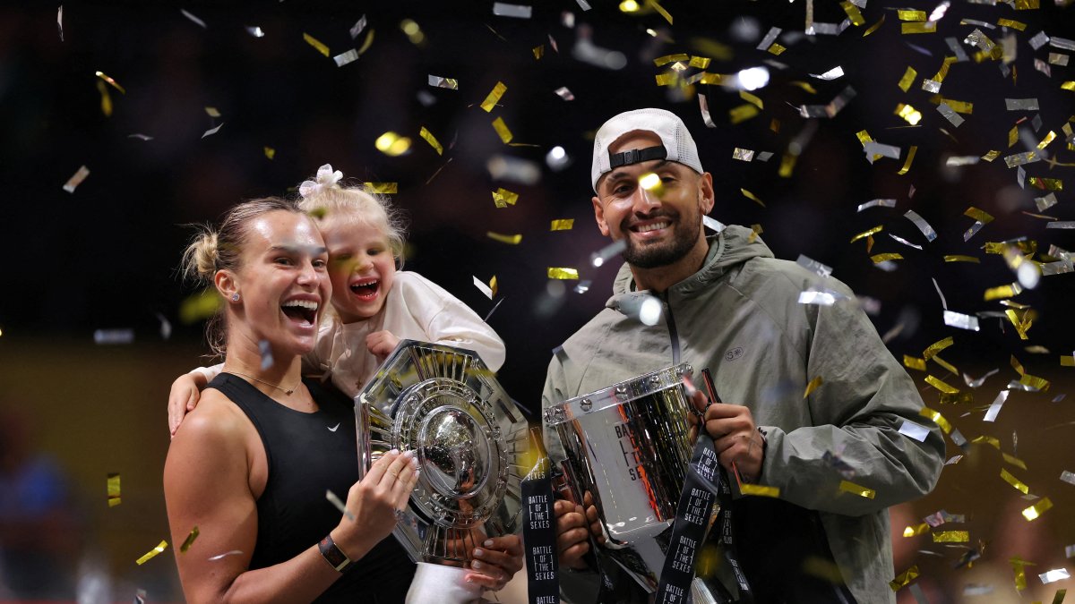Belarus' Aryna Sabalenka (L), her goddaughter Nicole, and Australia's Nick Kyrgios celebrate with trophies after the 'Battle of the Sexes' match at the Coca-Cola Arena, Dubai, UAE, Dec. 28, 2025. (Reuters Photo)