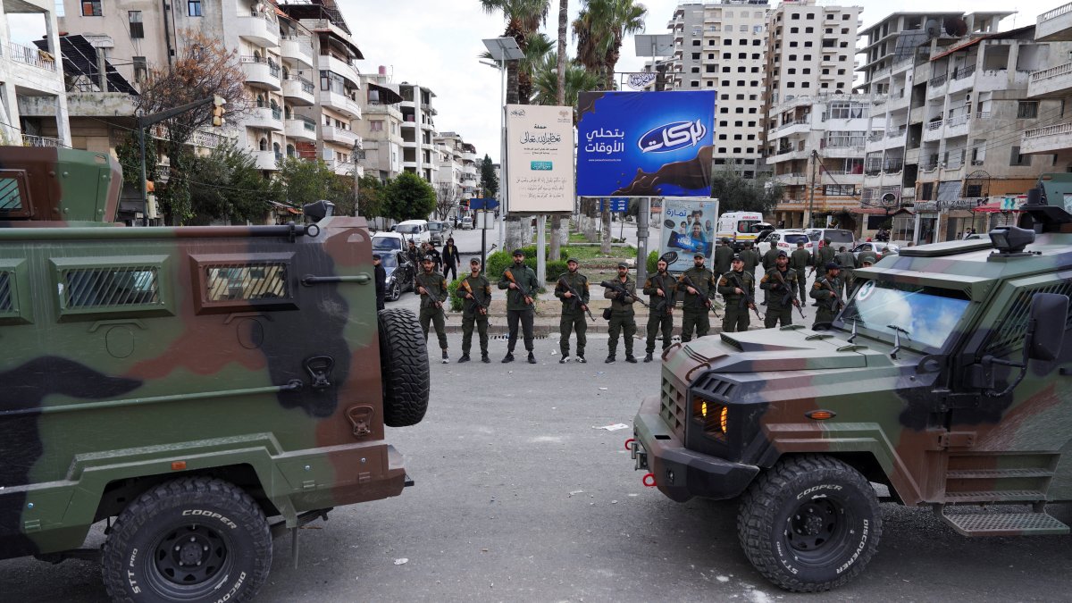 Members of the Syrian Security forces stand guard near military vehicles on the day people from the Alawite sect protest, Latakia, Syria, Dec. 28, 2025. (Reuters Photo)