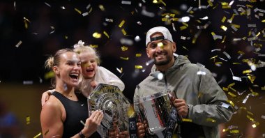 Belarus' Aryna Sabalenka (L), her goddaughter Nicole, and Australia's Nick Kyrgios celebrate with trophies after the 'Battle of the Sexes' match at the Coca-Cola Arena, Dubai, UAE, Dec. 28, 2025. (Reuters Photo)