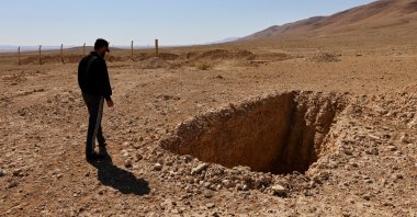 Ahmed Ghazal, a Syrian mechanic, approaches a hole he said was intended to be a burial trench in the secret mass grave created by the Assad regime, near the town of Dhumair, Syria, Feb. 27, 2025. (Reuters Photo)