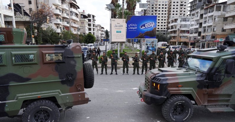 Members of the Syrian Security forces stand guard near military vehicles on the day people from the Alawite sect protest, Latakia, Syria, Dec. 28, 2025. (Reuters Photo)