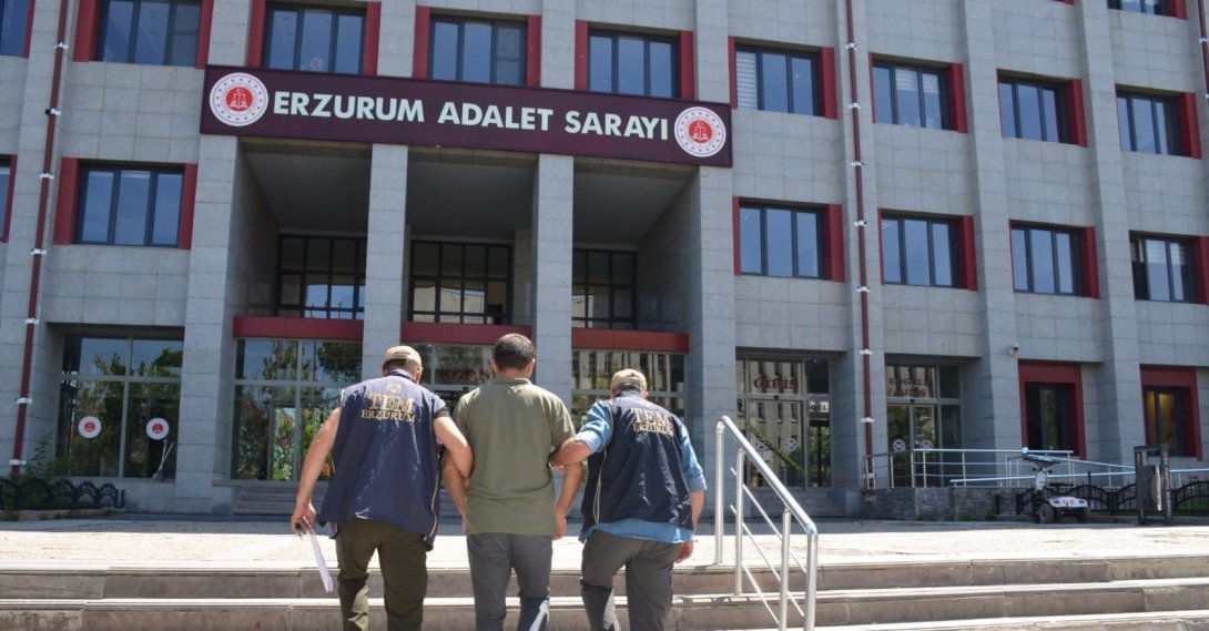Two police officers escort a detained FETÖ suspect, Erzurum, eastern Türkiye, July 18, 2025. (AA Photo)
