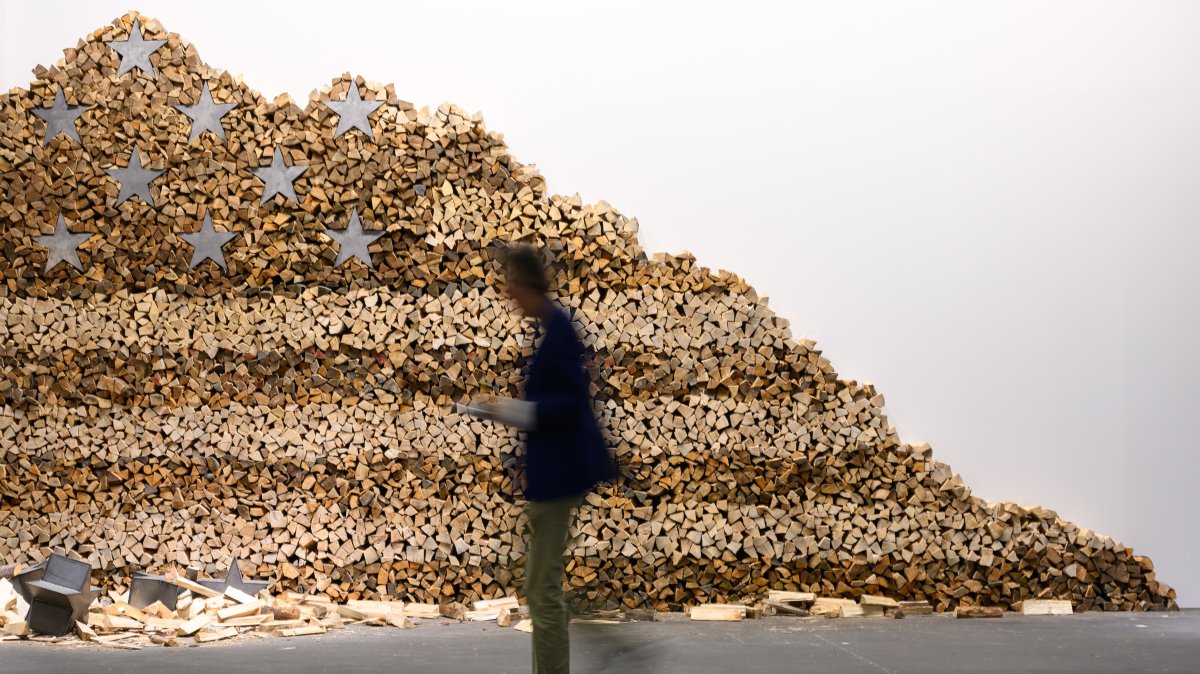 A visitor walks next to an artwork of Danh Vo, "In God We Trust" 2020, displayed at Art Basel at Messe Basel, Basel, Switzerland, June 17, 2025. (Getty Images Photo)
